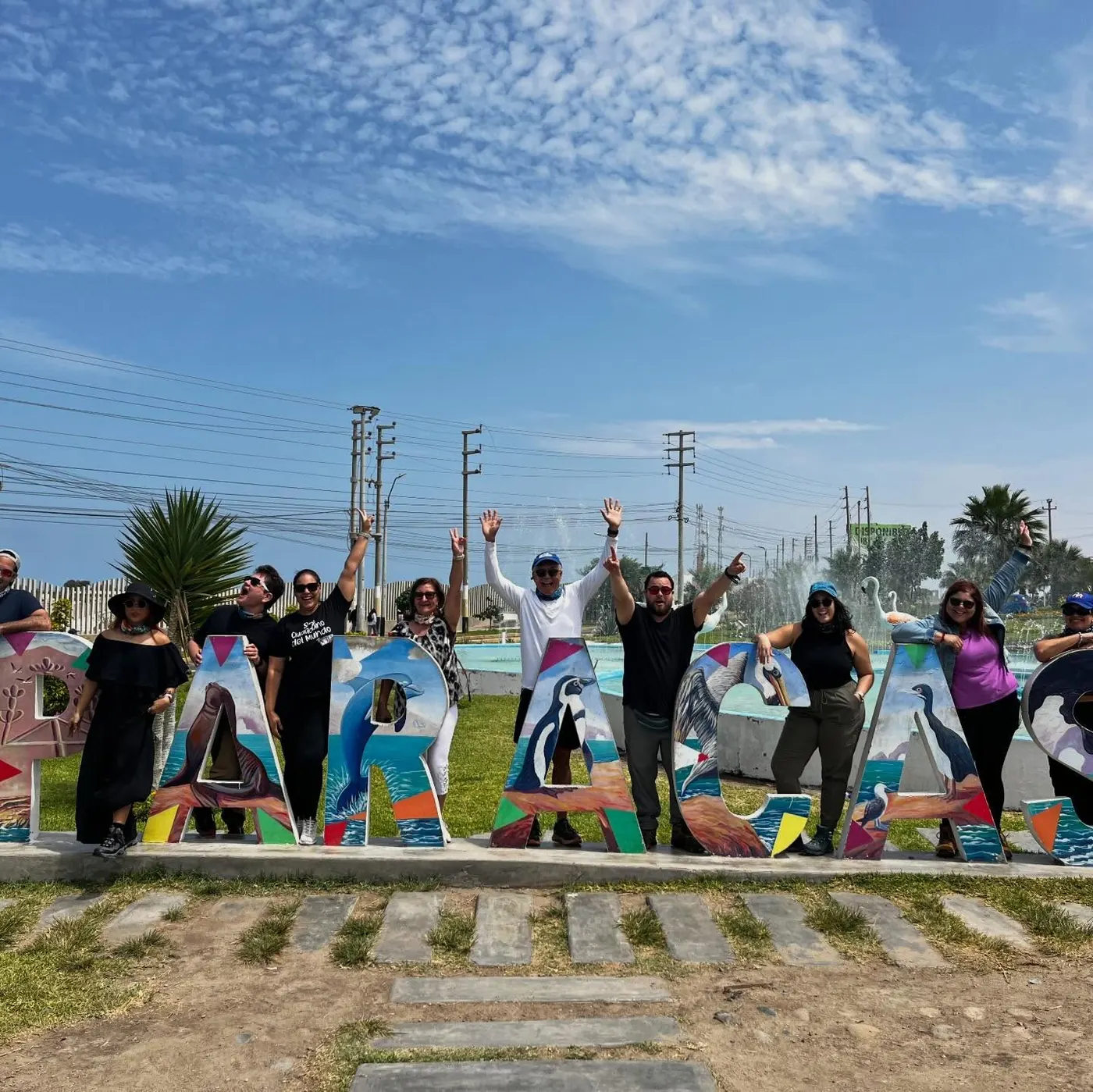 Grupo de viajeros frente a las letras de Paracas