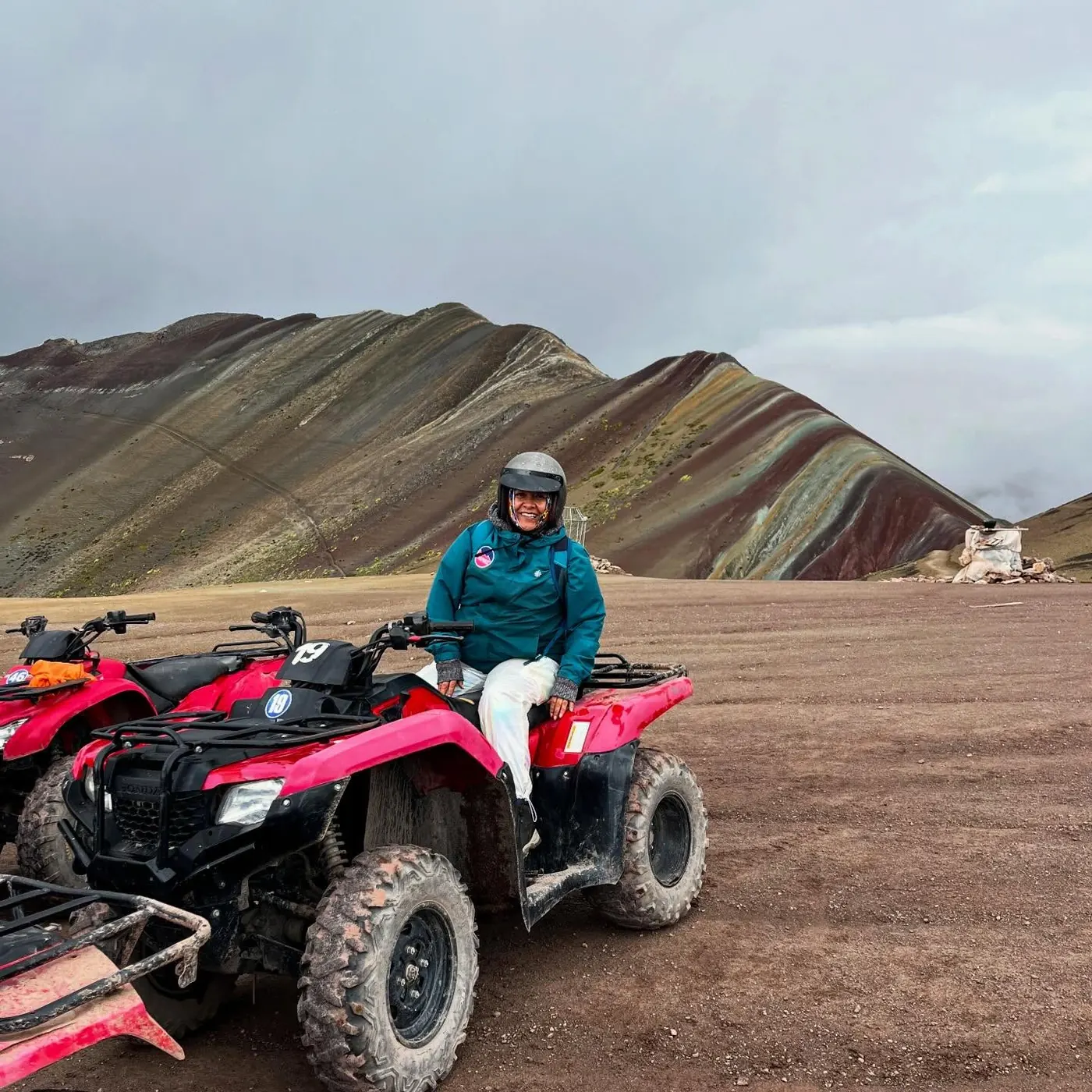 Viajera en cuatrimoto frente a la Montaña de 7 Colores