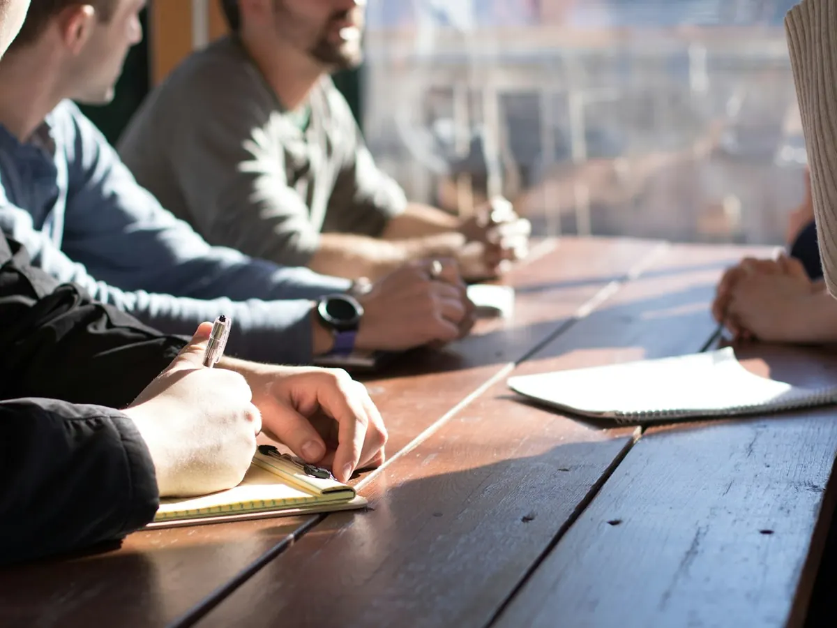 Reunión con cuadernos sobre una mesa de madera